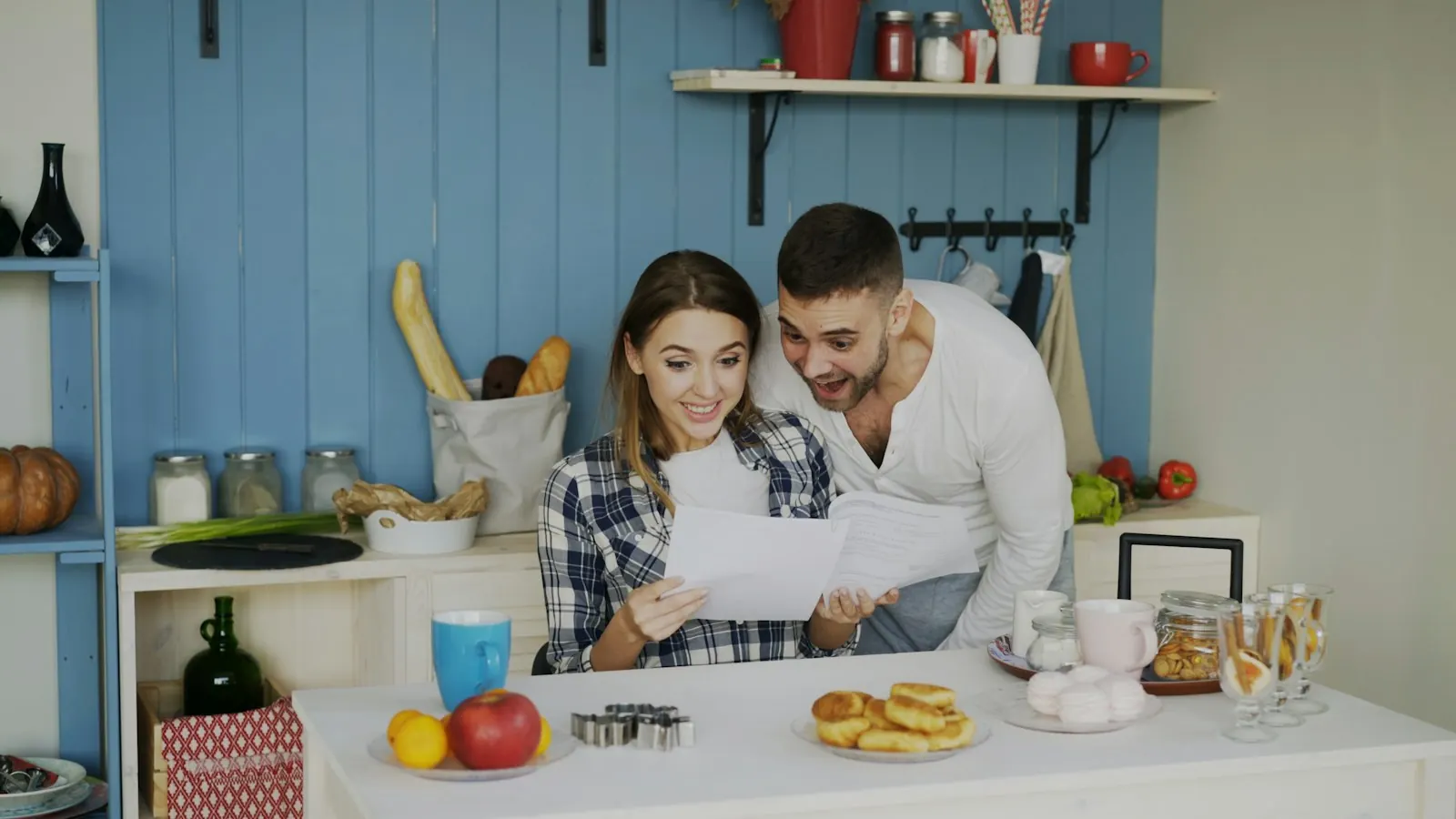 A couple reading papers together in their kitchen