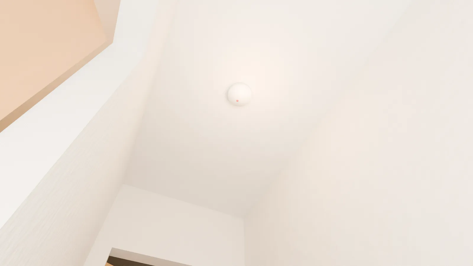 A carbon monoxide alarm on a hallway ceiling