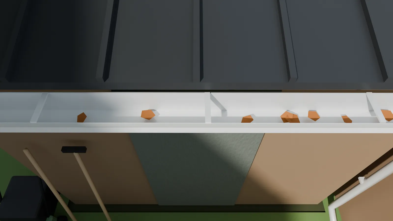 Leaves sitting in a white eavestrough under a metal roof