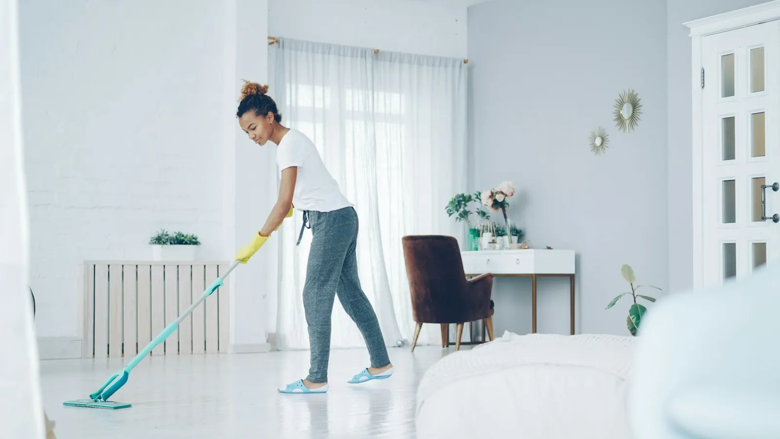 A person mopping a bright living room floor