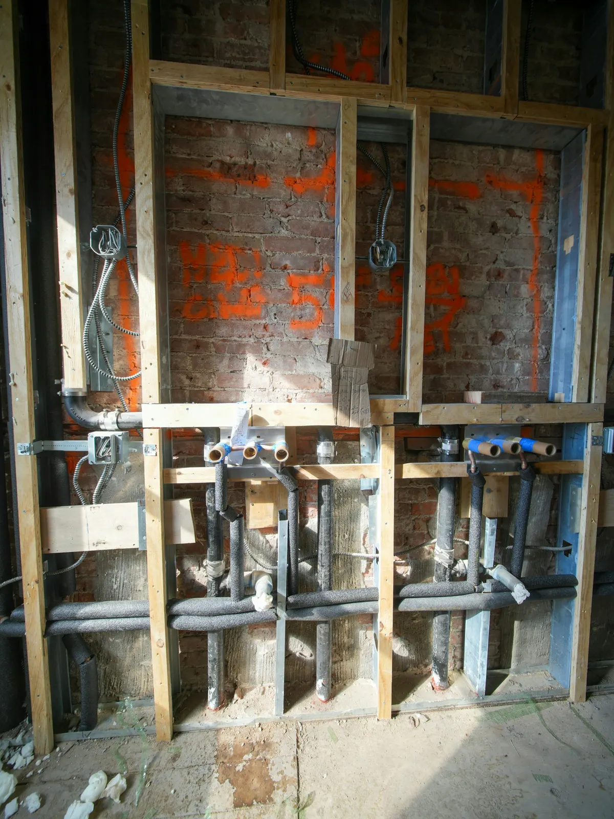 New plumbing pipes inside an open wall during a renovation