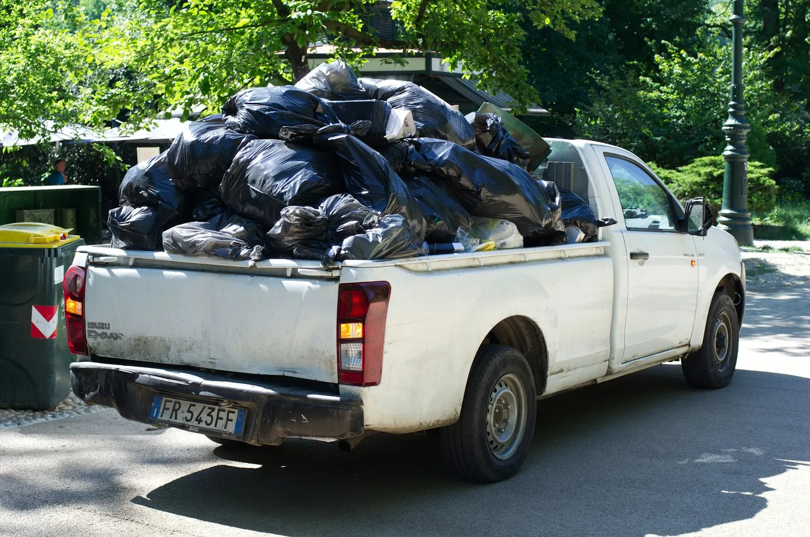 A pickup truck loaded with black garbage bags