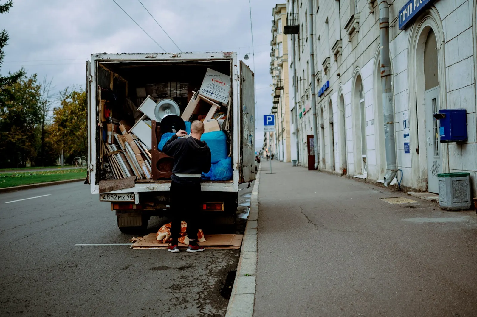 A mover unloading furniture from the back of a moving truck